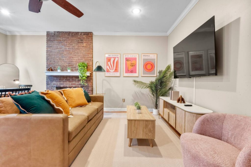 Bright living room at The Urban Oasis with exposed brick and colorful artwork