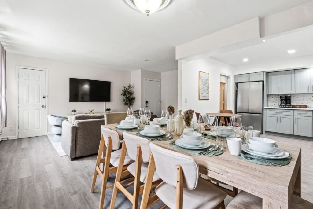 Dining table and open kitchen prepared for a group stay at The Luxe Escape